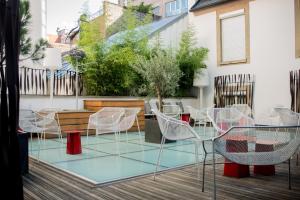 
a patio area with chairs, tables, and tables with umbrellas at HANNONG Hotel & Wine Bar in Strasbourg
