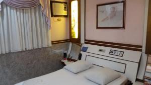 a bedroom with two beds and a picture on the wall at America Motel (ADULT ONLY) in Vila Anastácio