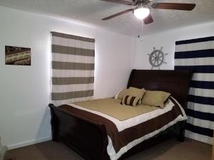 a bed in a bedroom with a ceiling fan at KY Lake Area Cabin in Aurora