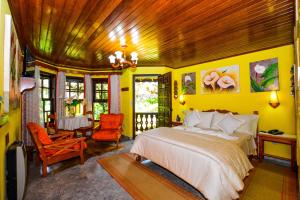 a bedroom with a bed and a table and chairs at Pousada Lago Azul in Monte Verde +287 photos
