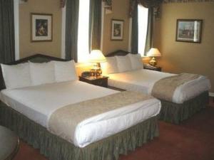 two beds in a hotel room with two lamps at Waynebrook Inn in Honey Brook