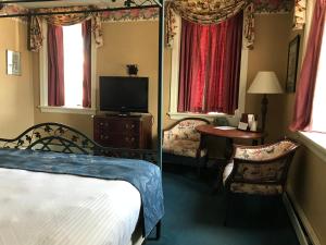 a bedroom with a bed and a tv and a table at Waynebrook Inn in Honey Brook