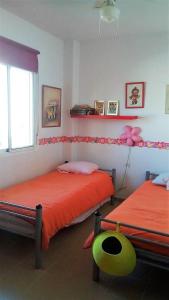 サンルーカル・デ・バラメダにあるCadiz Golfのベッドルーム1室(オレンジのシーツを使用したベッド2台付)