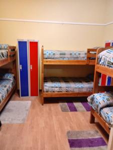 a room with three bunk beds and a door at Hostal Arenas del Mar in Viña del Mar