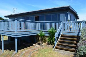 una casa con una terraza azul y escaleras en Panoramic Drive Holiday House, en Cape Bridgewater