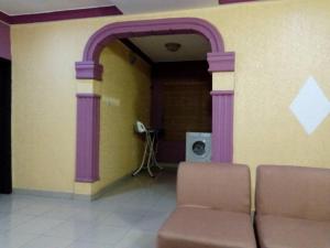 a room with a couch and a wall with purple pillars at Solar and Inverter Full Service 3 Bedroom Flats in Ikeja