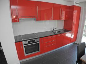 eine Küche mit roten Schränken und einem Waschbecken in der Unterkunft Casa Jorio App 9999 in Locarno