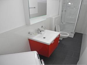 ein Badezimmer mit einem roten Waschbecken und einem WC in der Unterkunft Casa Jorio App 9999 in Locarno