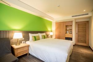 sypialnia z dużym łóżkiem i zieloną ścianą w obiekcie Green World Triple Beds w Tajpej