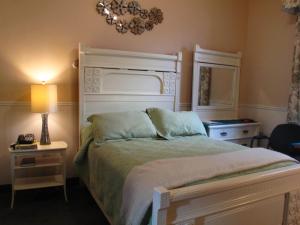 ein Schlafzimmer mit einem Bett, einem Kronleuchter und einer Lampe in der Unterkunft Garden South Park Inn in Halifax