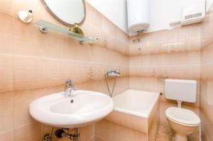 a bathroom with a sink and a toilet and a mirror at Apartments Mateo in Baška Voda +36 photos