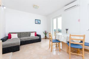 ein Wohnzimmer mit Sofa, Tisch und Stühlen in der Unterkunft Apartments ANDREA in Mandre + 19 Fotos