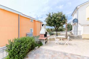 eine Terrasse mit einem Pizzaofen neben einem Gebäude in der Unterkunft Apartments ANDREA in Mandre