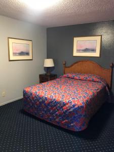 a bedroom with a bed with a colorful bedspread at Travelers INN in West Sacramento