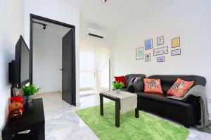 a living room with a black couch and a green rug at Setapak Rest House,15min to KLCC #217- Private Room in Kuala Lumpur