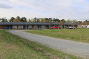 an empty road in front of a building at Four Oaks Lodging in Smithfield