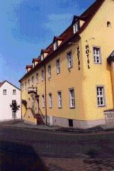 un grand bâtiment jaune sur le côté d'une rue dans l'établissement Hotel "Zur Sonne", à Querfurt