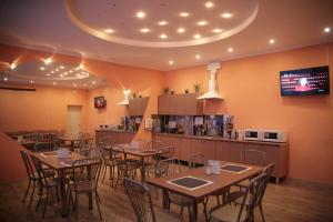 ノヴォシビルスクにあるHostel Evraziaのテーブルと椅子のあるレストラン、キッチンが備わります。