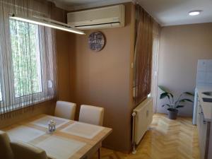 a dining room with a table and chairs and a window at Apartment Cherry in Zrenjanin