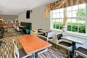 a restaurant with tables and chairs and windows at Microtel Inn & Suites by Wyndham Cherokee in Cherokee