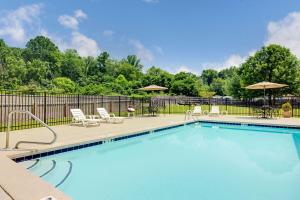una piscina con sedie, tavoli e ombrelloni di Microtel Inn & Suites by Wyndham Cherokee a Cherokee