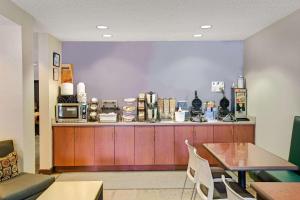 Microtel Inn & Suites by Wyndham Cherokee في شيرروكي: مطبخ مع طاولة وطاولة مع ميكروويف