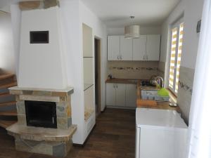 a kitchen with a stone fireplace and a stove at U Eskulapa Bieszczady in Lutowiska