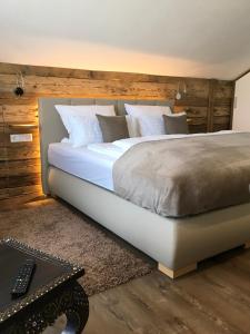 a bedroom with a large bed with a wooden wall at Shania Residence in Übersee