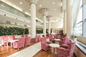 un vestíbulo con mesas y sillas rosas en un edificio en Ark Hotel Okayama -ROUTE INN HOTELS-, en Okayama