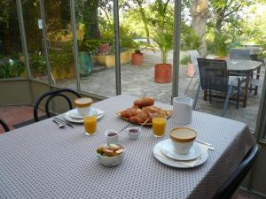 einen Tisch mit einem Frühstück mit Kaffee und Gebäck darauf in der Unterkunft Chambres d'hôtes de la gardy in Eyragues