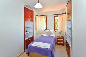 1 dormitorio con 1 cama con sábanas y estanterías moradas en Villa Beste en Dalyan