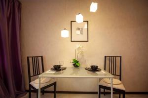 トリヤッチにあるDark Paris Apartment SUTKI LIFEのテーブル、椅子、白いテーブル、照明