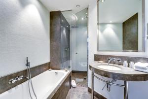 a bathroom with a tub and a sink at Hôtel Le A - Champs-Elysées in Paris