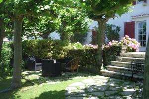 a garden with chairs and pink flowers and trees at Chambres d'hôtes GELA ITSASOA Baie in Ciboure