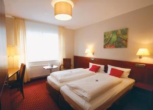 pokój hotelowy z 2 łóżkami i oknem w obiekcie Schlafgut Hotels in Reken w mieście Reken