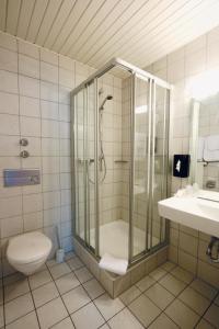 a bathroom with a shower and a toilet and a sink at Schlafgut Hotels in Reken in Reken