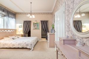 - une chambre avec un lit et un grand miroir dans l'établissement Royal, à Riga
