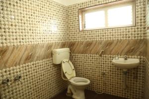 a bathroom with a toilet and a sink at Hotel Vijay in Pollāchi