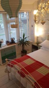 a bedroom with a bed with a red and yellow blanket at Heavenly Retreat in Corsham