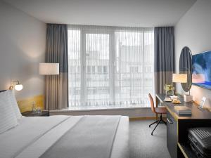 a hotel room with a large bed and a desk at K+K Hotel Fenix in Prague