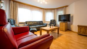 a living room with a couch and a television at Haus Alpenglück in Saas-Fee