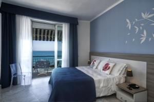 a bedroom with a bed with a view of the ocean at Hotel Bel Sit in Alassio