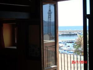 a window with a view of the water and a tower at Holiday home Santa Flavia in Santa Flavia