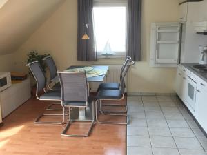 a kitchen with a table and chairs in a room at Ferienwohnung MÖWENNEST ARENDSEE in Kühlungsborn