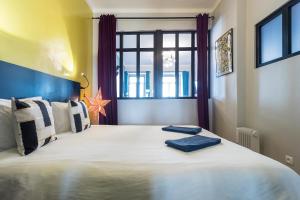 a bedroom with a large white bed with a window at Chiado Bairro Alto, Bright and Newly Renovated 3 Bedroom Apartment, Lisbon Historical Center in Lisbon