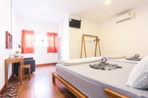 um quarto com uma cama e uma secretária num quarto em The Garage em Chiang Rai