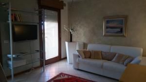 a living room with a white couch and a television at Atelier in Portogruaro