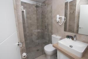 een badkamer met een douche, een toilet en een wastafel bij Apartamentos Soho Boutique Museo in Málaga