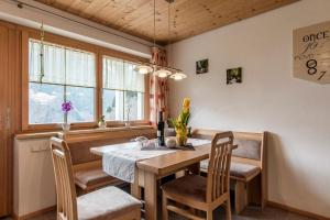 - une salle à manger avec une table, des chaises et des fenêtres dans l'établissement Haus Ambiatscha, à Sankt Gallenkirch