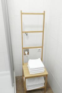 a bathroom with a shelf and a table with towels at City-Apartments Langegger in Vienna